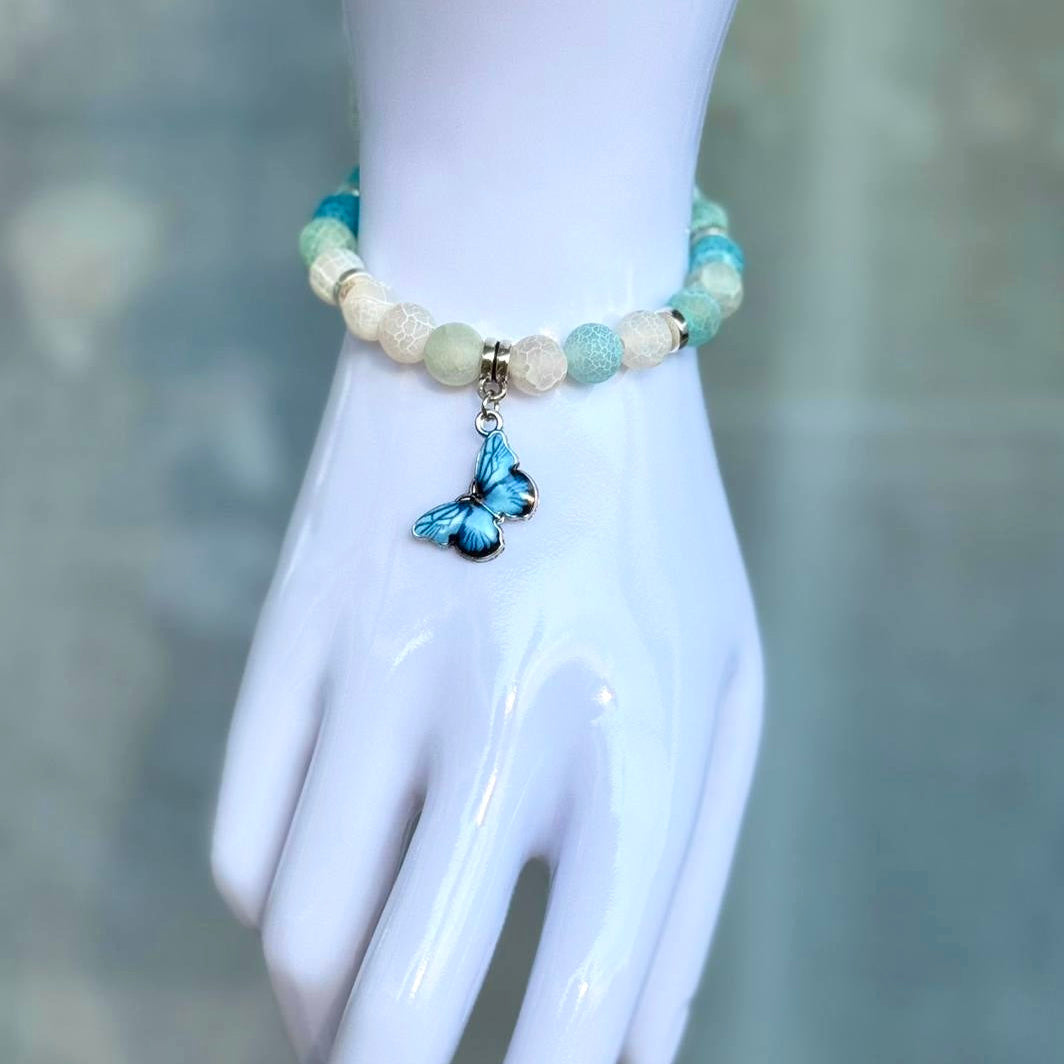 Blue Butterfly Natursteinarmband mit Schmetterlings-Anhänger am Handmodell