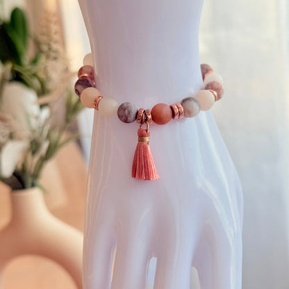 Handgefertigtes Natursteinarmband in Rosa- und Cremetönen mit Roségold-Akzenten am Handmodell