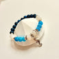 Meereszauber Armband mit Seepferdchen-Anhänger und Crackle-Natursteinperlen in Blau und Weiß auf weißem Hintergrund