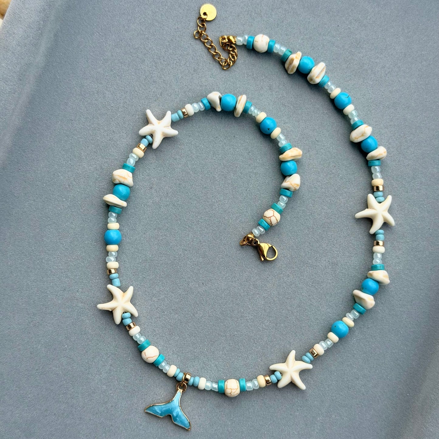Ocean Whisper Halskette – Detailansicht auf blauem Hintergrund